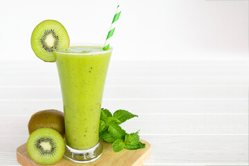 Kiwi yogurt fruit juice smoothie and green kiwi juice drink healthy, delicious taste in a glass for weight loss on a white wooden background.
