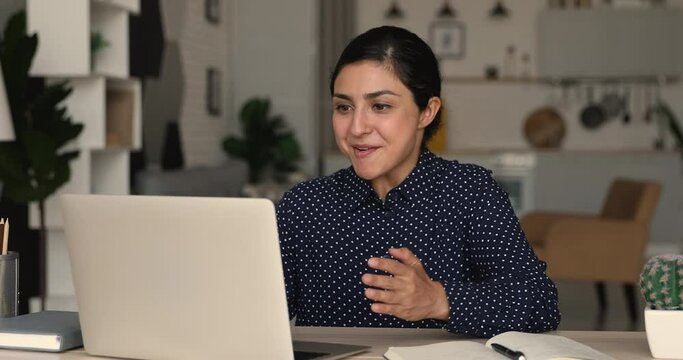 Indian ethnicity woman sit at desk using laptop read e-mail notification celebrate good news, sales growth, career advance, loan acceptance from bank, online lottery gambling victory moment concept