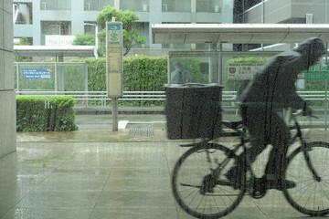 激しい雨の日の風景、走る配達人