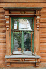 Windows on the facade of an old wooden house is in disrepair. A house in the village. Russia.
