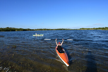 Woman and active senior kayaking on Nine Mile Pond in Everglades National Park on clear sunny April afternoon.