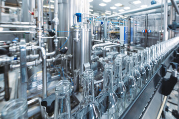 Obraz premium Production line transports empty glass bottles for alcohol