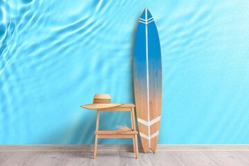 Stand and surfboard near wall with print of clear blue water