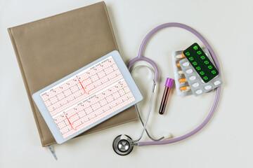 An heart report analysis the electrocardiogram viewed on digital tablet with a stethoscope in workplace of doctor