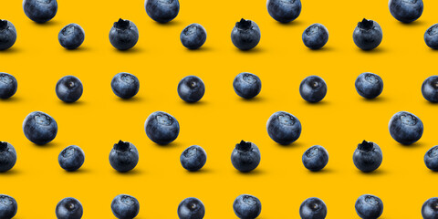 Many ripe blueberries on yellow background. Pattern for design