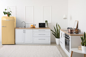Interior of light modern kitchen with stylish yellow refrigerator