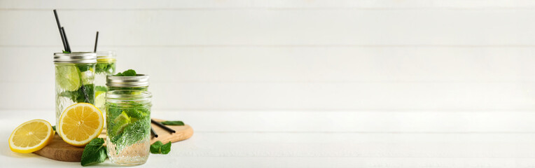 Jars of fresh mojito on light background with space for text