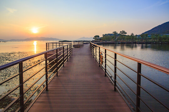 A long plank bridge and sunset in Dongqian lake wetland of mashan