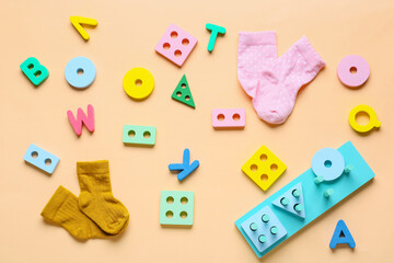Children building blocks with letters and socks on beige background