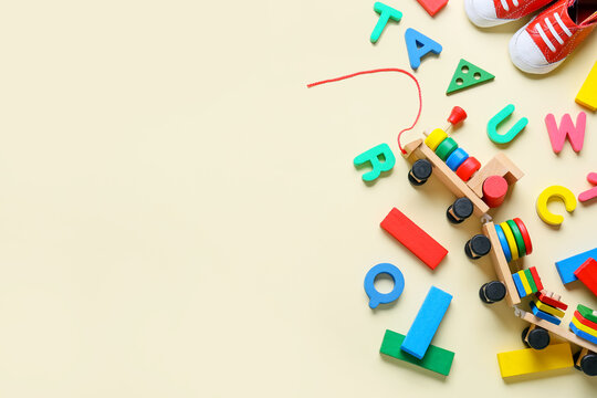 Toy Train With Building Blocks, Letters And Booties On Beige Background