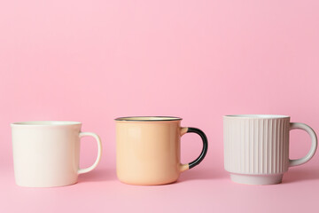 Obraz na płótnie Canvas Different cups on pink background