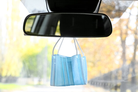 Medical Mask Hanging On Rear View Mirror In Car