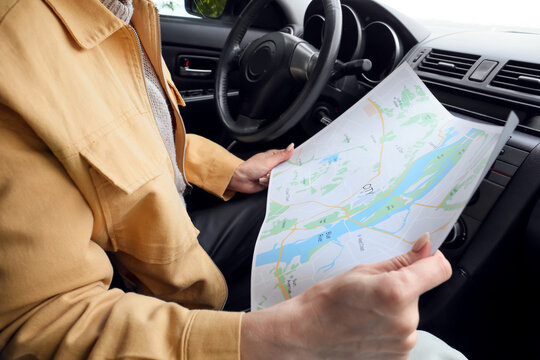 Female driver with city map in car, closeup