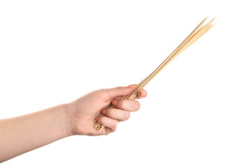 Female hand with wooden skewers on white background