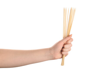 Female hand with wooden skewers on white background