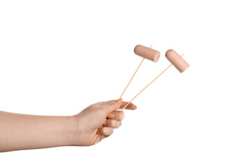 Female hand holding wooden skewers with sausage on white background