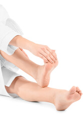 Young woman making foot massage on white background, closeup
