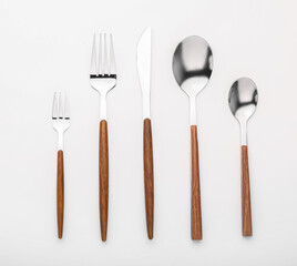 Set of stainless steel cutlery with wooden handle on white background
