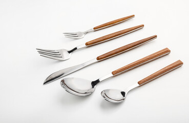 Set of stainless steel cutlery with wooden handle on white background