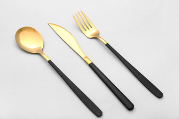 Set of stainless steel cutlery with black handle on white background