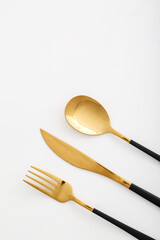 Set of stainless steel cutlery with black handle on white background, closeup
