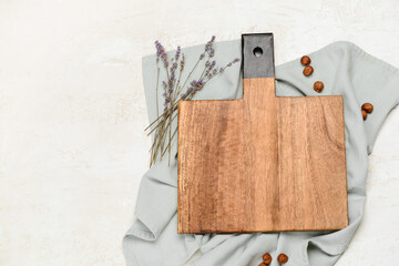 Wooden cutting board and lavender flowers on light background