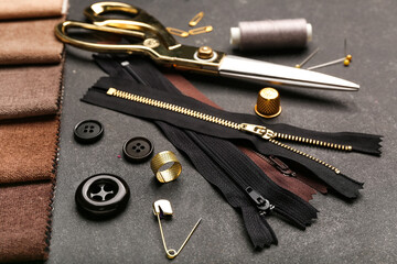 Set of stylish zippers and sewing supplies on dark background © Pixel-Shot