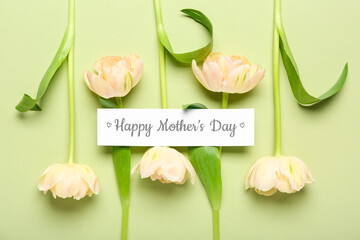 Paper with text HAPPY MOTHER'S DAY and flowers on green background
