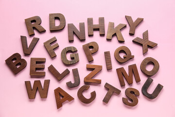 Wooden letters on pink background. Alphabet concept