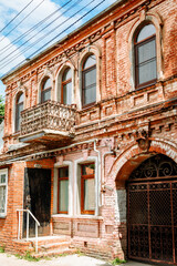 The facade of an old brick one-story house of the last century. historical landmark city walks
