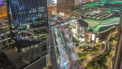 Fototapeta na wymiar Aerial panorama of Downtown Dubai with shopping mall and traffic on a street night timelapse from above, UAE