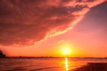 Sunset on the beach giant cloud in the sky and sun