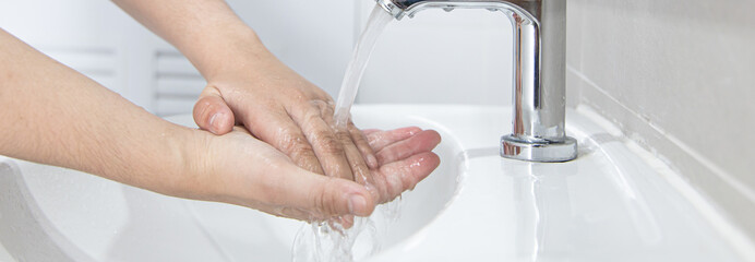 Men are washing their hands in the sinks to clear respiratory bacteria and viruses, sanitation and...