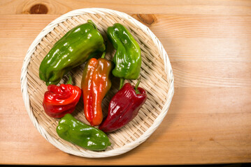 ザルの上の色んな色のピーマン