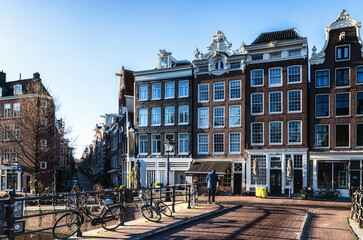Urban landscape in Amsterdam Netherlands. Panorama street with bicycle tree and road traditional Dutch architecture.