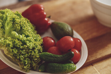 Close-up of a plate with fresh vegetables laid out on it for salad