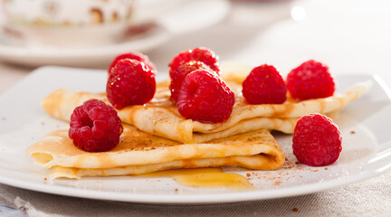delicious pancakes with fresh raspberries and honey