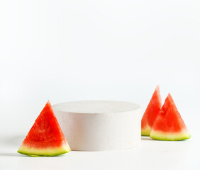 Empty white modern podium with watermelon slices at light background. Copy space for product...