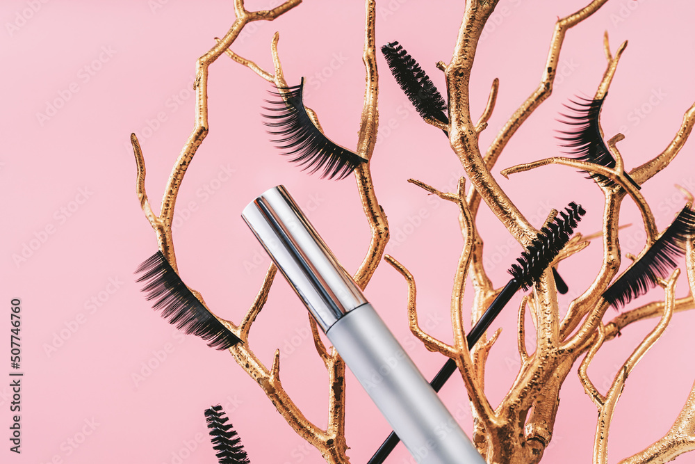 Wall mural tender pink feminine makeup tools and accessories.mascara with false lashes eyelash on golden branch