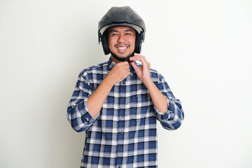 Adult Asian man smiling while tighten his motorcylce helm strap