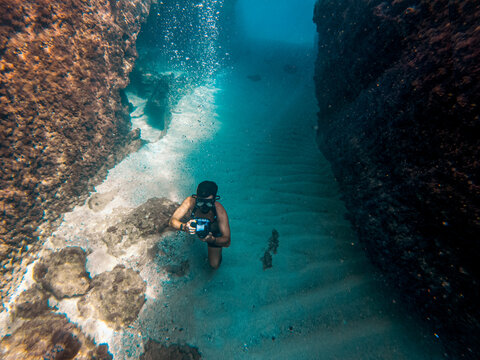 Photographer taking photos underwater. Swimming in Blue crystal Mediterranean water.