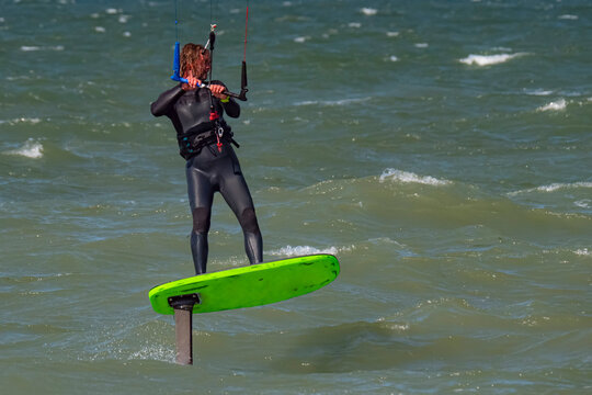 Male Kite Foil Surfer with beard and long hair on the sea. Close up