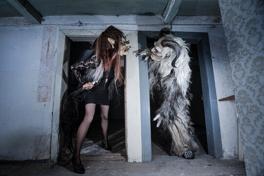 Monster and witch looking at each other standing at doorway of horror house