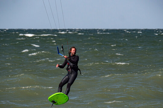 Male Kite Foil Surfer with beard and long hair on the sea. Close up
