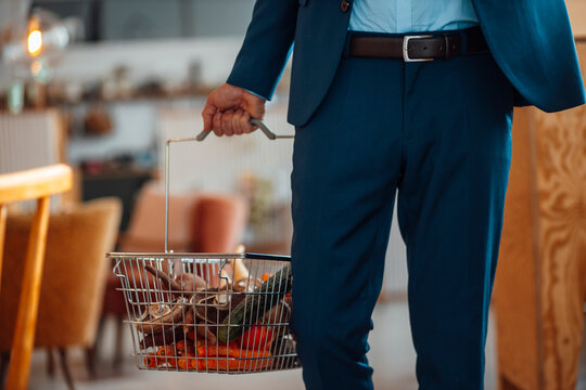 Mature businessman holding basket of vegetables