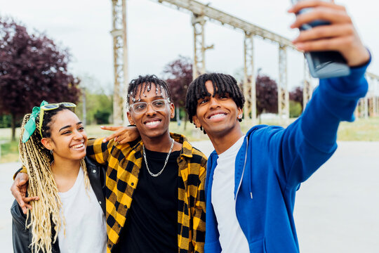 Happy man taking selfie with friends through smart phone
