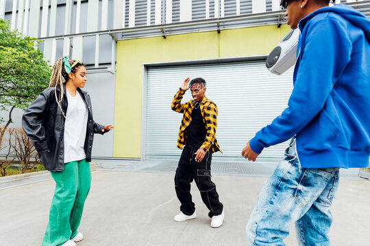 Young friends dancing in front of shutter