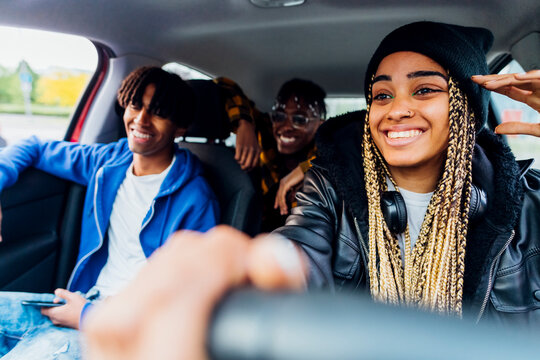 Smiling woman sitting in car with friends