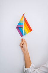 Hand woman holding rainbow flags isolated on white concrete backgrounds.
