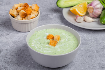 Vegan cream cold soup with cucumber, yogurt, garlic, herbs, lemon and croutons. Diet food concept. Vegetarian and vegan food